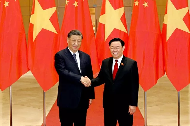 O presidente chinês, Xi Jinping, à esquerda, e o presidente vietnamita da Assembleia Nacional, Vuong Dinh Hue, apertam as mãos enquanto posam para uma foto na assembleia nacional em Hanói, Vietnã 