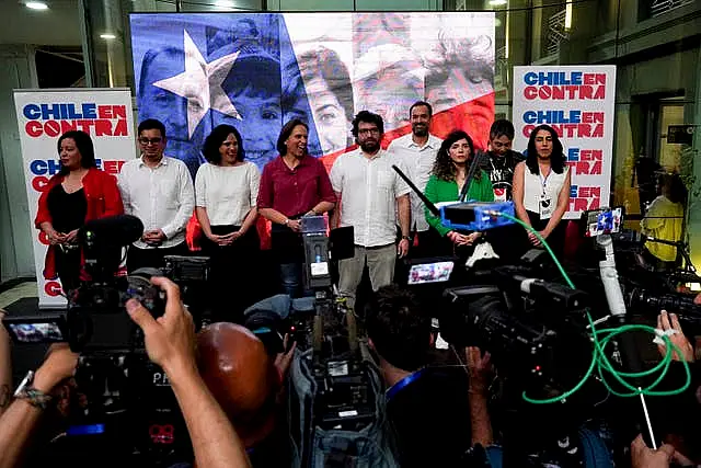 Members of the campaign team against the draft of a new constitution talk to journalists after the polls close