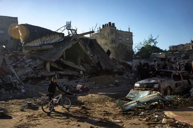 Palestinians search for bodies and survivors in the rubble of a residential building destroyed in an Israeli airstrike in Rafah, southern Gaza Strip, on Friday
