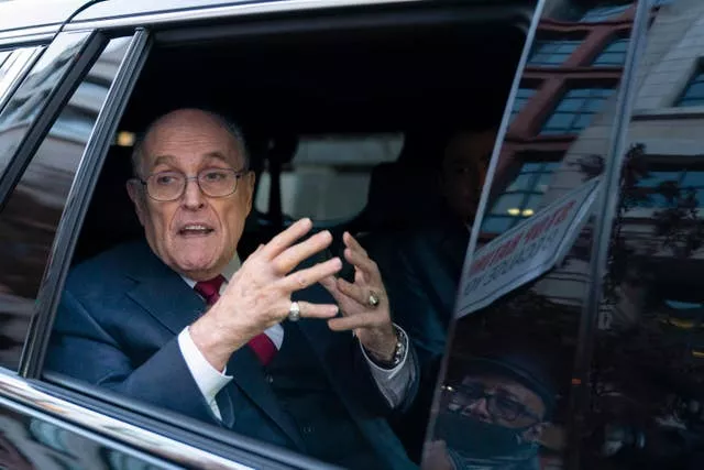 Rudy Giuliani in the back seat of a car