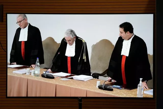 A screen shows Vatican tribunal president Giuseppe Pignatone reading the verdict of the trial