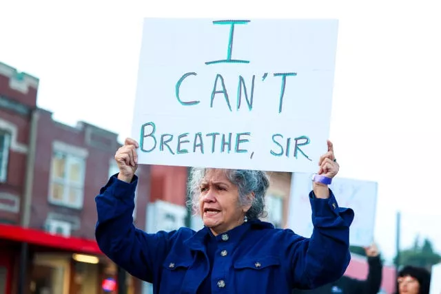 A protester holds a sign during a rally after the verdict was read during the trial