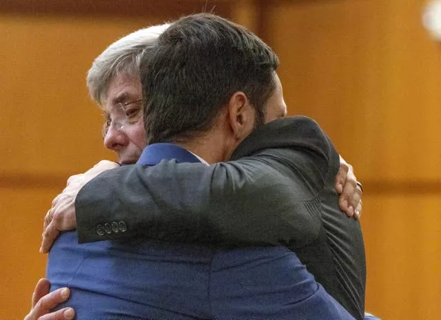 O policial de Tacoma, Christopher Burbank, à direita, recebe um abraço de seu advogado Wayne Fricke depois de ser declarado inocente