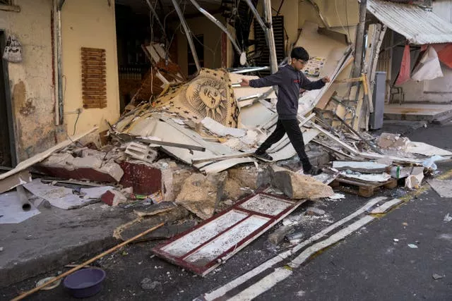 A Palestinian boy walks through the aftermath of the Israeli military raid on Nur Shams refugee camp in the West Bank