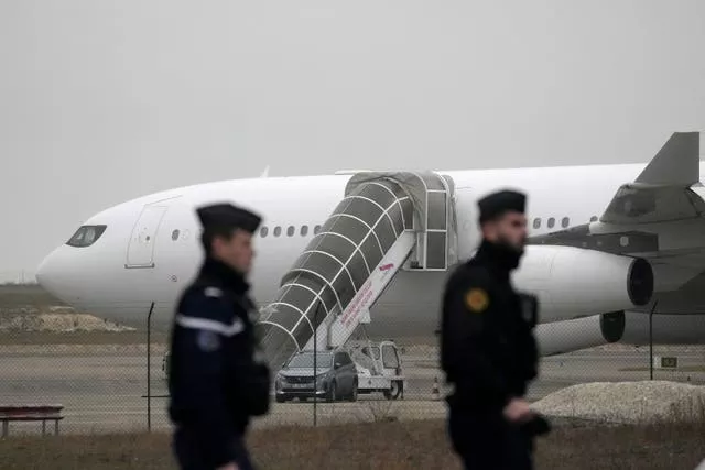 Gendarmes patrol by the plane grounded by police based that it could be carrying trafficking victims, at the Vary airport in Vatry, eastern France 