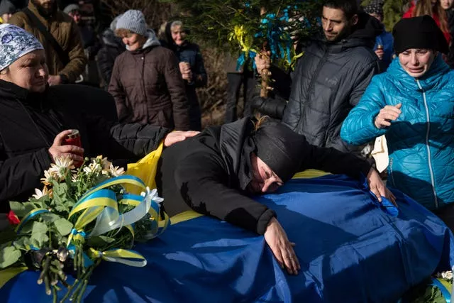Hanna Boichuk chora durante o funeral de seu filho Vasyl Boichuk, um militar ucraniano morto em Mykolayiv em março de 2022, em Verkhovyna, Ucrânia, na terça-feira, 26 de dezembro de 2023