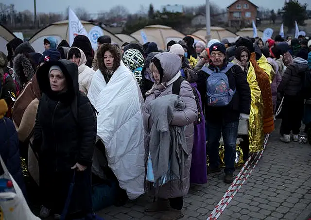 Refugees wait in a crowd for transportation after fleeing from Ukraine and arriving at the border crossing in Medyka, Poland, last March