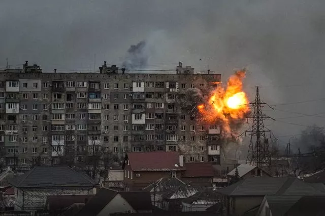 An explosion erupts from an apartment building at 110 Mytropolytska St., after a Russian army tank fired on it in Mariupol, Ukraine (Evgeniy Maloletka/AP)