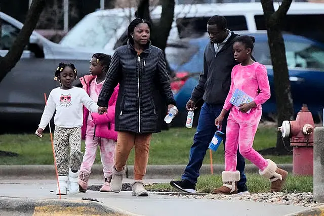 A couple with three young girls on the pavement