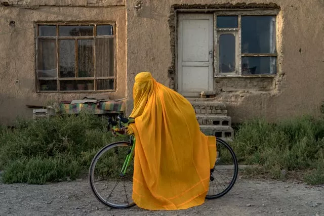 A woman in a burqa on a bike