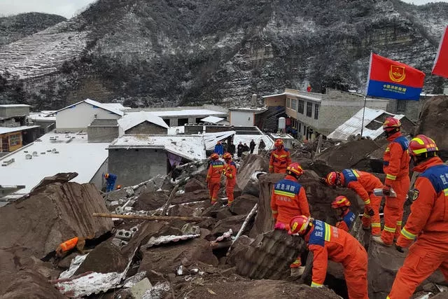 Rescue workers search the site of a landslide in Liangshui village in Yunnan Province 
