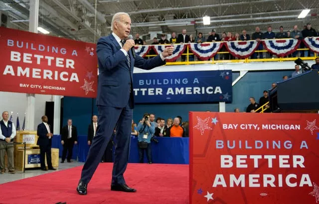 President Joe Biden on a platform with signs reading Build a Better America