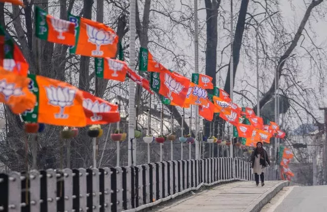 A woman walk past India’s ruling Bharatiya Janata Party flags