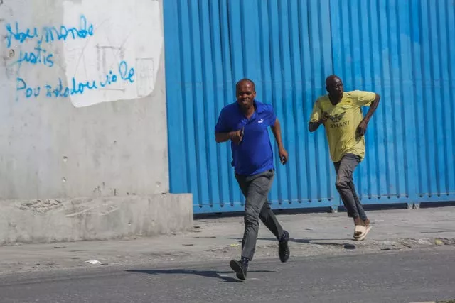 Pedestrians run for cover after hearing gunshots in Port-au-Prince 