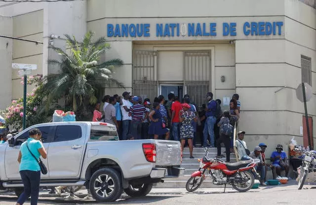 People line up outside a bank that had been closed for several days due to the violence in Port-au-Prince 