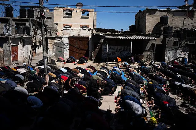 Palestinians perform the first Friday prayers of the Muslim holy month of Ramadan near the ruins of a destroyed mosque in Rafah