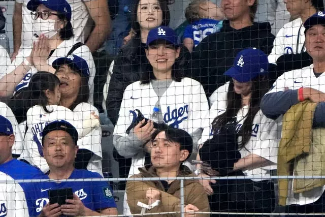 Mamiko Tanaka, centro, esposa de Shohei Ohtani, do Los Angeles Dodgers, assiste durante um jogo de beisebol no dia de abertura entre o San Diego Padres e os Dodgers no Gocheok Sky Dome em Seul, Coreia do Sul 