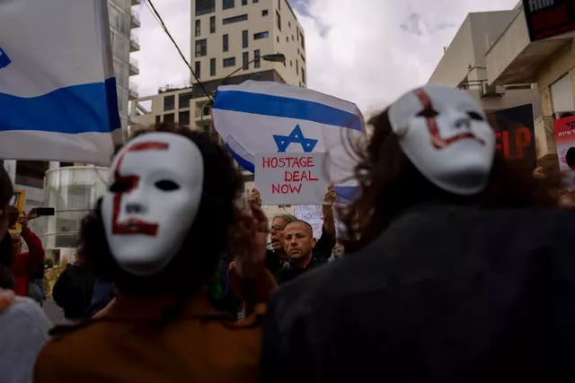 Les familles et les partisans des otages israéliens détenus par le Hamas à Gaza brandissent des banderoles et des drapeaux israéliens et américains lors d'une manifestation exigeant leur retour, devant une réunion entre le secrétaire d'État américain Antony Blinken et les familles des otages, à Tel Aviv, en Israël.