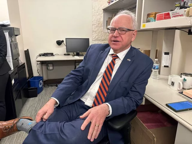 Tim Walz sits on a chair