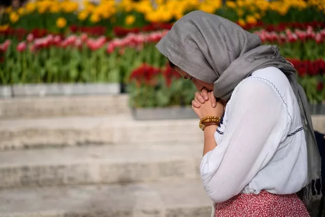 A faithful prays in St Peter’s Square