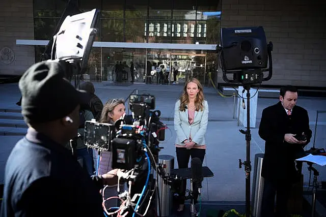 Press wait in front of a federal courthouse in Los Angeles