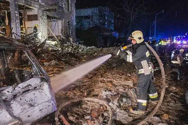 Um bombeiro trabalha para extinguir um incêndio depois que um ataque com mísseis russos atingiu um hotel em Kharkiv, na Ucrânia, na noite de quarta-feira.