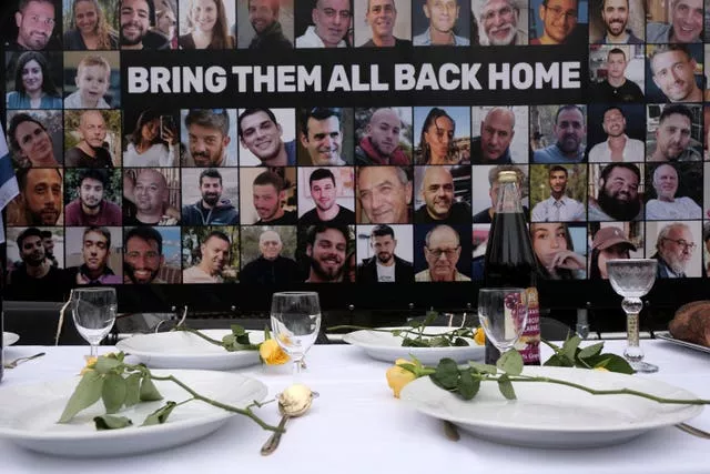 Pictures of hostages kidnapped during the October 7 Hamas cross-border attack in Israel are placed by a table set during a protest outside the International Court of Justice in The Hague, Netherlands