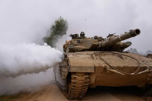 An Israeli army tank moves near the Israeli-Gaza border, in southern Israel, on Wednesday