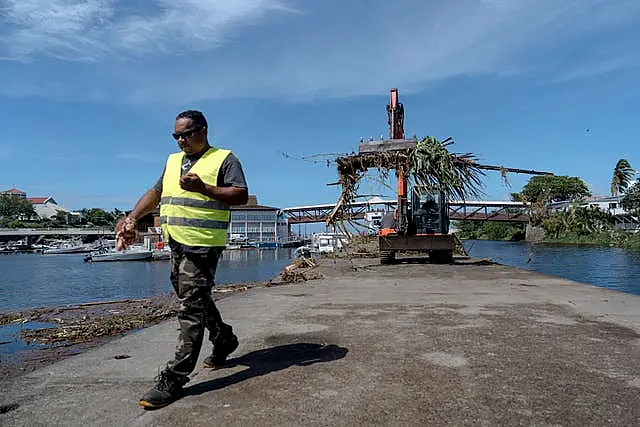 Workers clean up trees and debris on the marina of Saint-Gilles les Bains on the French Indian Ocean island of Reunion