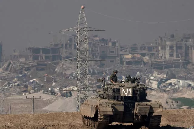 Israeli soldiers overlook the Gaza Strip from a tank