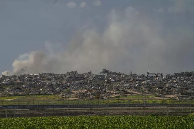 A fumaça sobe por trás dos escombros dos edifícios destruídos na operação terrestre do Exército israelense na Faixa de Gaza, vista do sul de Israel, adjacente à cerca da fronteira de Gaza