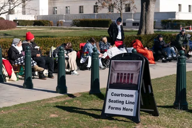 People wait in line outside the US Supreme Court in Washington