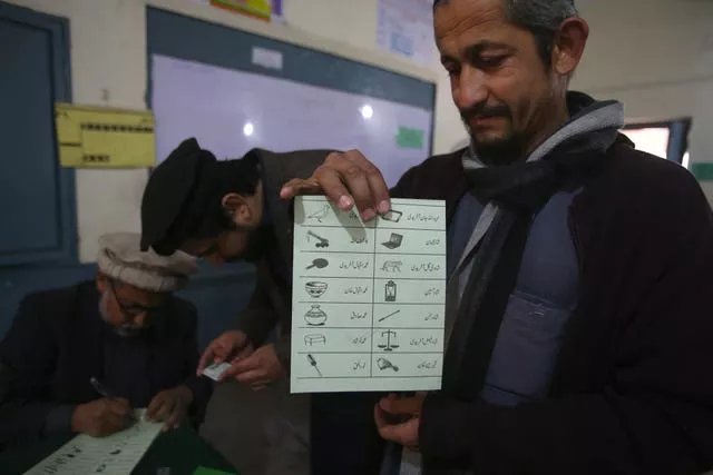 A man shows a ballot paper before casting his vote at a polling station during the country’s parliamentary elections in Jamrud, in the Khyber district, Pakistan 