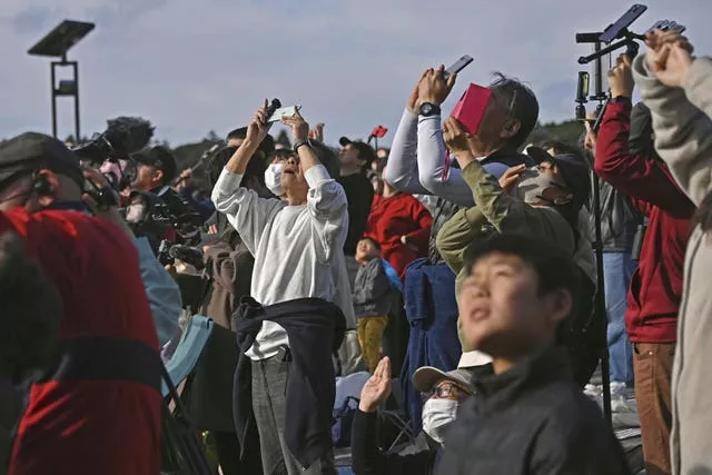 Pessoas na cidade de Minamitane, Kagoshima, sul do Japão, observam um foguete H3 decolar do Centro Espacial Tanegashima