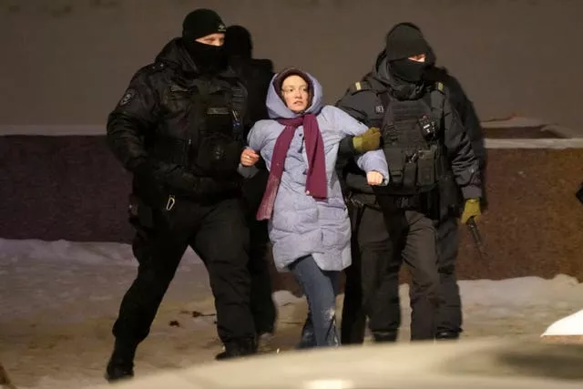 Police officers detain a woman who laid flowers for Alexei Navalny at the Memorial to Victims of Political Repression in St Petersburg, Russia