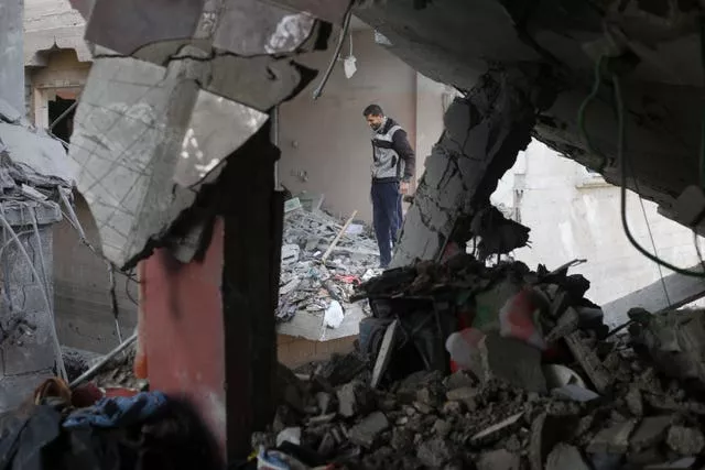A Palestinian looks at the destruction after an Israeli strike on a residential building in Rafah, Gaza (Hatem Ali/AP)