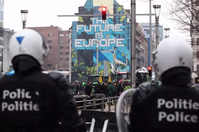 Police face farmers and tractors at a security checkpoint in Brussels 