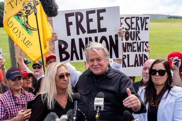 Steve Bannon speaks to supporters with placards outside Danbury Federal Correctional Institution alongside Marjorie Taylor Greene