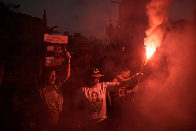 Anti-war protester in Tel Aviv with a red flare