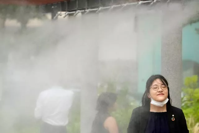 People cool off at a cooling mist spot in Tokyo