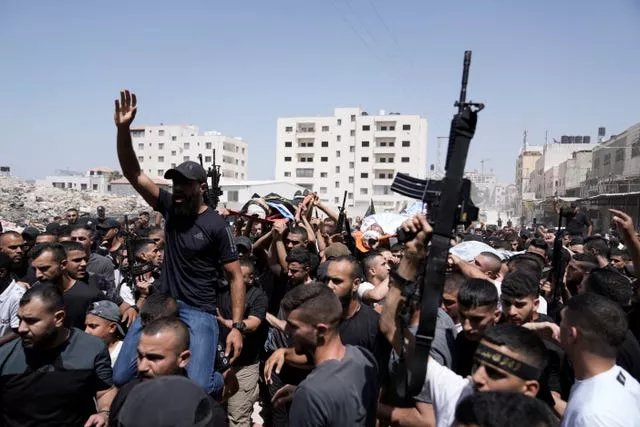 Gunmen march in the funeral for three people killed in an Israeli military operation, in Jenin refugee camp in the West Bank city of Jenin