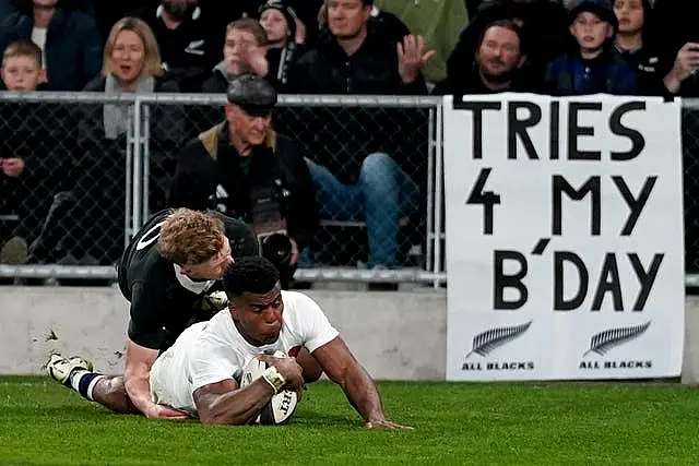 Immanuel Feyi-Waboso slides in to score a try in front of a banner reading 'Tries 4 my bday'