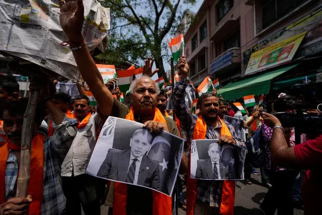 Protesters prepare to burn photographs of Pakistan Prime Minister Shehbaz Sharif 