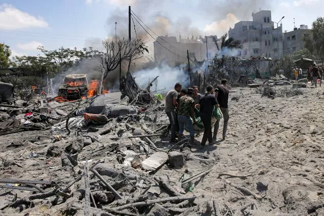 Palestinians evacuate a body from a site hit by an Israeli bombardment on Khan Younis