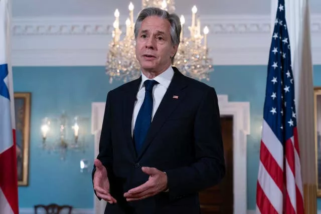 US secretary of state Antony Blinken speaks next to an American flag