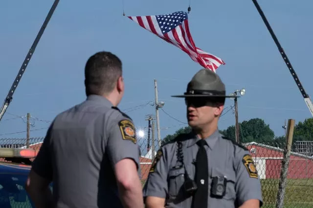 Police officers stand at a road leading to the site of the Trump rally in Butler, Pennsylvania