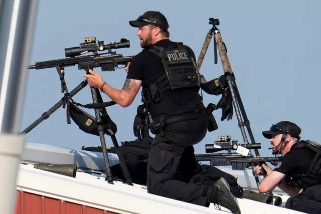 Two police snipers with guns on tripods