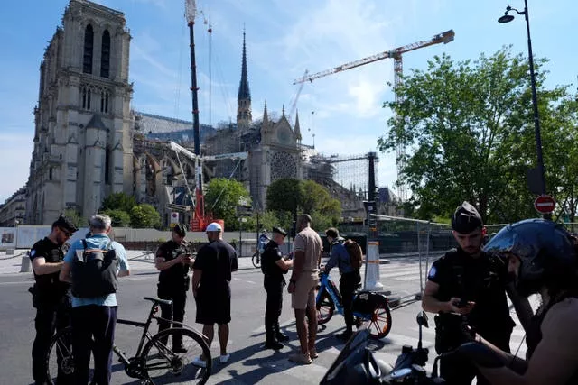 Police check people with bicycles at the security perimeter outside Notre Dame cathedral 