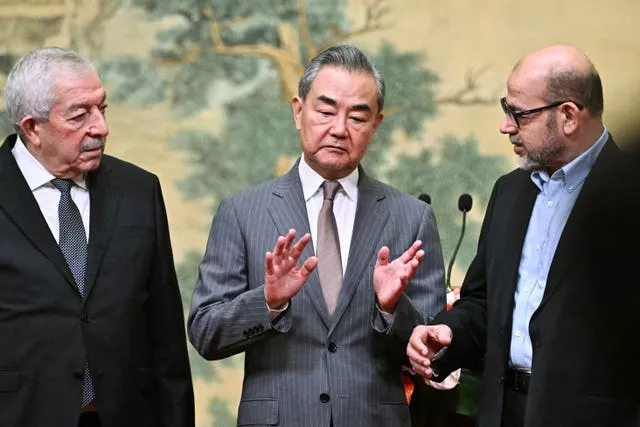 China’s Foreign Minister Wang Yi, center, hosts an event for Mahmoud al-Aloul, left, vice chairman of Fatah, and Mussa Abu Marzuk, a senior member of Hamas,