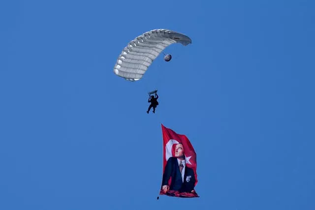 A Turkish parachuter prepares for a landing as fly over the military parade with a Turkish flag 